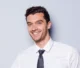 Portrait d’un homme souriant en chemise et cravate.
