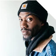 Portrait d’un homme portant un bonnet et une veste de travail.