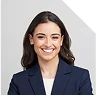 Portrait d’une femme souriante en tenue professionnelle.