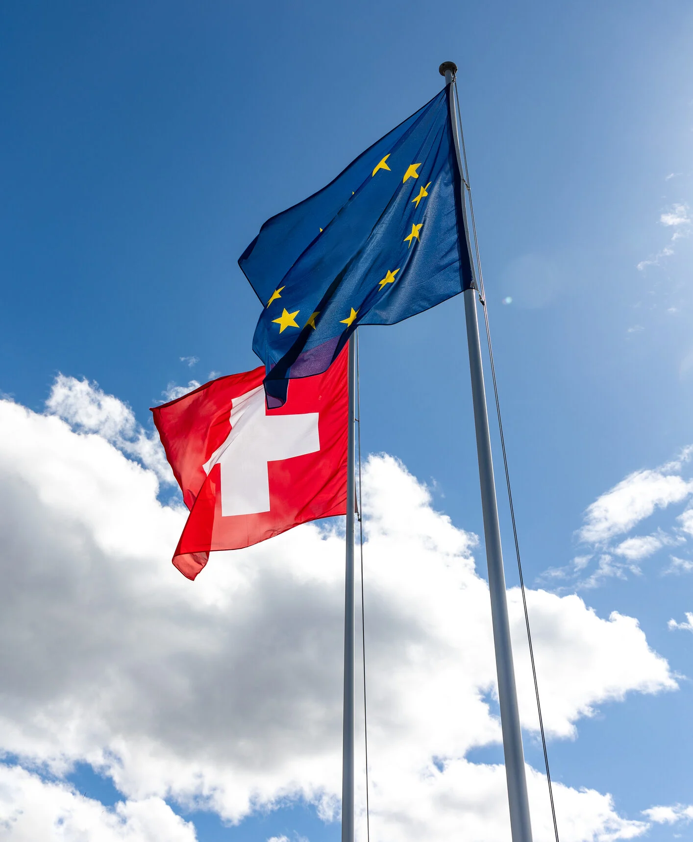 Bandiere della Svizzera e dell'Unione europea che sventolano affiancate.
