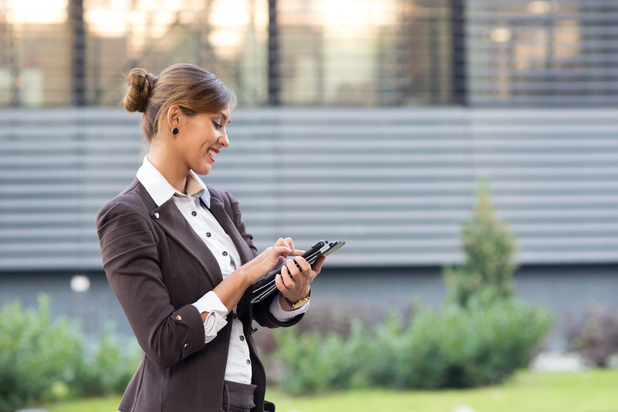Persona in abbigliamento professionale che utilizza un tablet all'aperto.