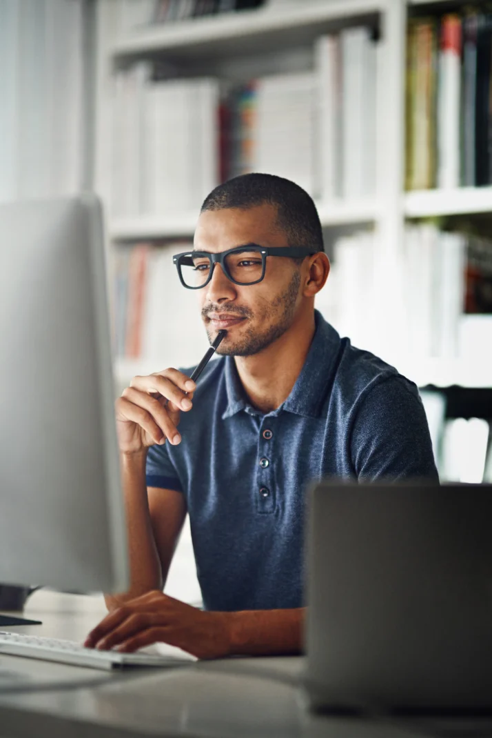 Personne travaillant sur un ordinateur dans un environnement de bureau.