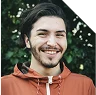 Portrait d’un homme souriant en extérieur.